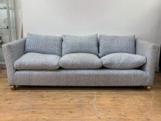 A contemporary three seat sofa, upholstered in a patterned blue and white cotton, with loose