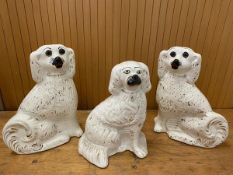 A pair of 19thc Staffordshire chimney spaniels one repaired measures 28cm high and another (3)