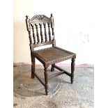 A 19th century Anglo-Indian chair, possibly padouk, with scrolled crest rail over turned spindle