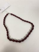 A graduated string of oval amber beads (18cm)