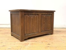 An oak blanket box, the hinged lid over two panel linen fold carved front, raised on stile