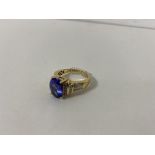 An 18ct gold dress ring with oval cut stone flanked by multiple diamond points (O/P) (6.94g)