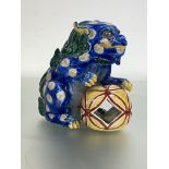 A Chinese pottery model of a lion dog, modelled with large "fabric" ball, glaxed in blue, green,