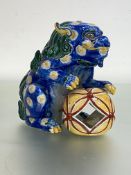 A Chinese pottery model of a lion dog, modelled with large "fabric" ball, glaxed in blue, green,