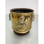 A brass coal bin, early 20th century, decorated in relief with a troubador, with lion-mask ring