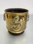 A brass coal bin, early 20th century, decorated in relief with a troubador, with lion-mask ring