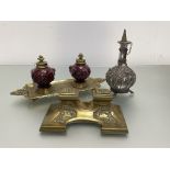 A 19th century brass and glazed pottery double inkstand, the wells in a red glaze, moulded with