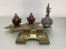 A 19th century brass and glazed pottery double inkstand, the wells in a red glaze, moulded with