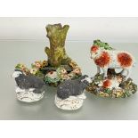 A group of Staffordshire models of sheep, 19th century comprising: a pair of seated sheep with