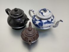 A group of three teapots: the first, Chinese, of compressed spherical form, decorated in blue and