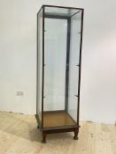 A shop display cabinet, early 20th century, the glazed top over a full length door (lacking