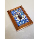 A 19th century Persian tile, modelled in relief with a mounted warrior carrying a spear, framed.