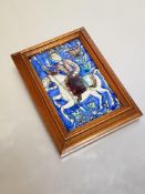 A 19th century Persian tile, modelled in relief with a mounted warrior carrying a spear, framed.