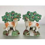 A pair of 19th century Staffordshire pearlware models of a standing ram and ewe with bocage, each