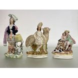 A group of three 19th century Staffordshire figures comprising: a Highland figure with a sheep, on a