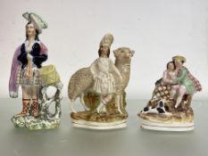 A group of three 19th century Staffordshire figures comprising: a Highland figure with a sheep, on a