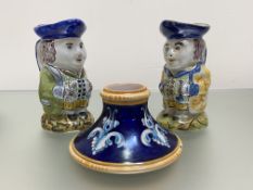 A pair of small French faience toby jugs, each modelled seated holding a glass, painted marks;