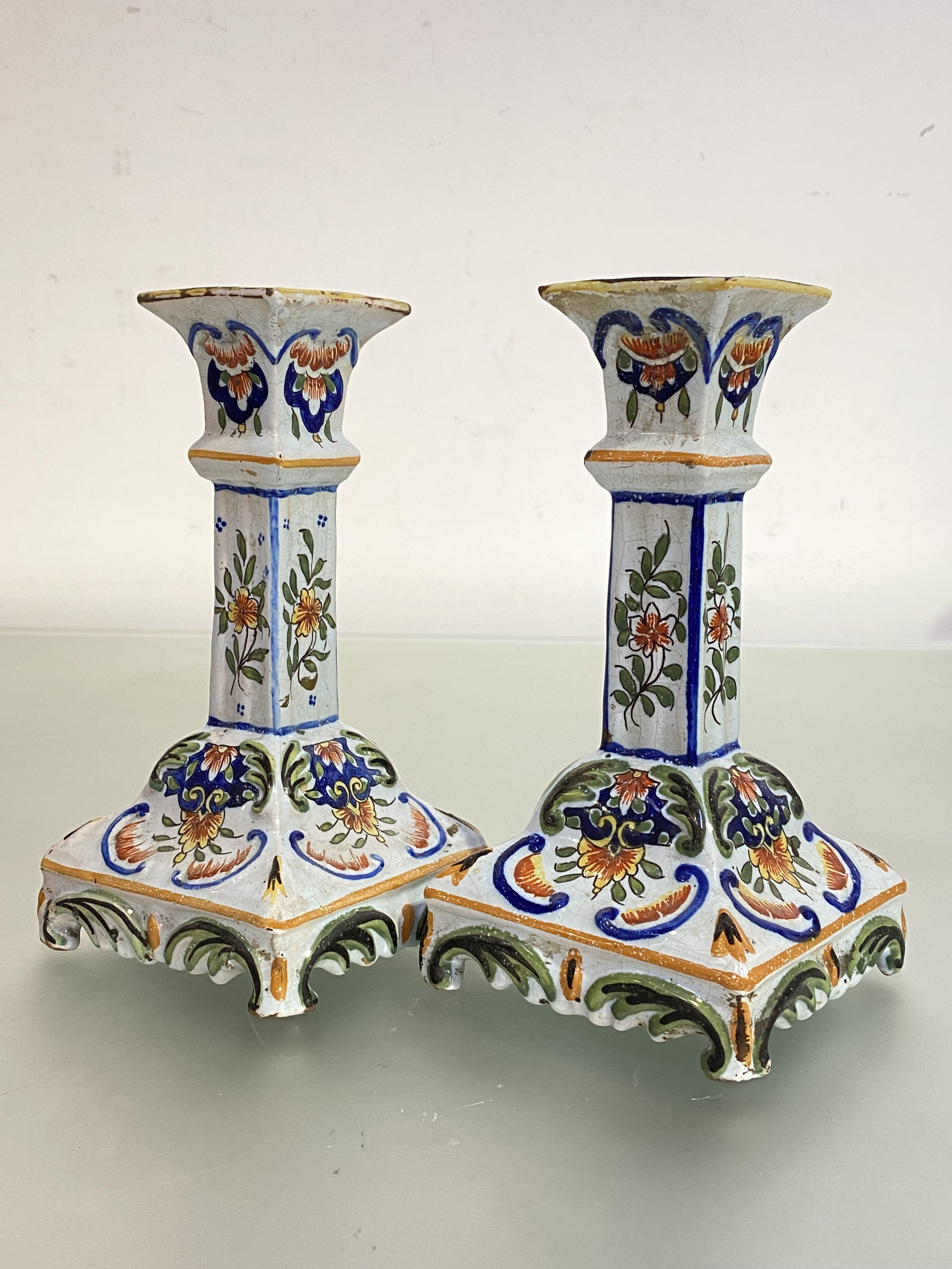 A pair of Rouen faience candlesticks, each with square shaft on a shaped square base. 18cm