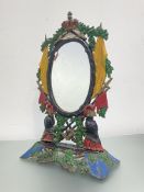 A painted cast-iron toilet mirror, the oval swing plate within a frame cast with military trophies