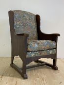 A 1930's oak framed armchair, the back and squab cushion in an embroidered fabric worked with