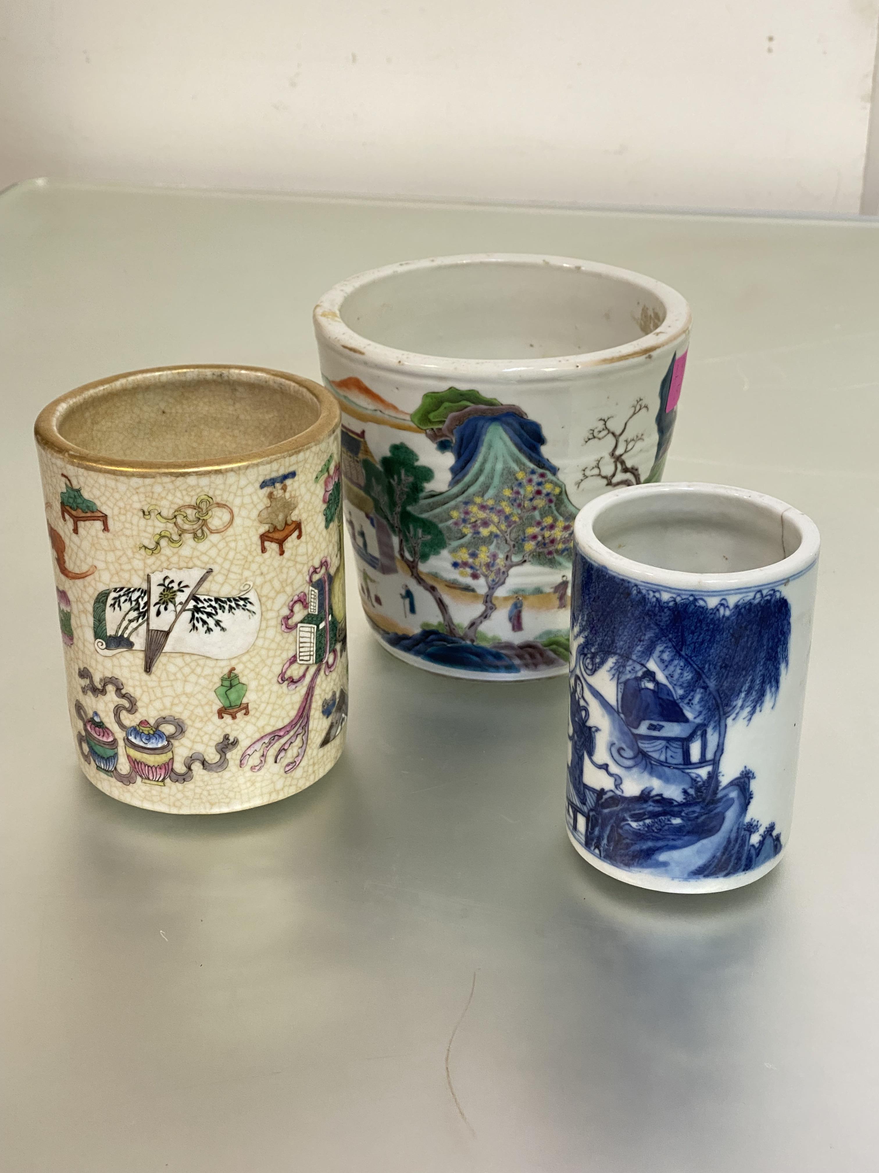 Two Chinese porcelain brush pots: the first blue and white, painted with figures on a bridge in a