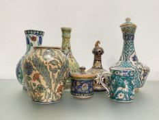 A group of Middle Eastern pottery vessels, four with decoration of Iznik design comprising: a