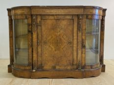 A Victorian figured walnut credenza, the moulded and stepped bow front top over a frieze with