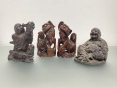 A group of four Chinese wooden carvings: a pair of lion dogs, each with glass eyes, modelled seated;