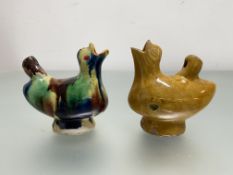 Two glazed terracotta bird whistles, each modelled with open beak, one in a Whieldon type drip
