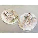 A pair of German porcelain oval plaques, c. 1900, oval, one modelled in relief with a winged
