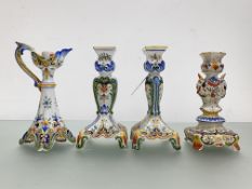 A group of French faience candlesticks comprising: a pair, of flattened baluster form, on square