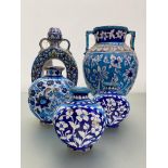 A group of Persian glazed terracotta vessels, each decorated with flowers in shades of turquoise and