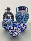 A group of Persian glazed terracotta vessels, each decorated with flowers in shades of turquoise and