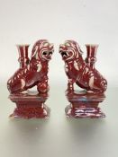 A pair of Chinese pottery incense burners modelled as lion dogs, in a sang de boeuf or oxblood