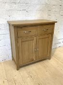 A modern oak sideboard, fitted with two drawers above twin cupboard doors, raised on stile supports,