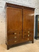 A Georgian mahogany cupboard, the dentil cornice over strung frieze with conch paterea, the twin