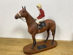 A Beswick figure of horse and jockey wooden base with label inscribed Red Rum measures 32cm high