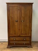 A hardwood double wardrobe, the twin panelled doors enclosing interior fitted for hanging, with