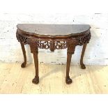A Chinese hardwood demi-lune side table, with plate glass top, pierced frieze, raised on scrolled