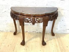 A Chinese hardwood demi-lune side table, with plate glass top, pierced frieze, raised on scrolled
