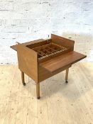 A teak drinks cabinet, circa 1950-1960, the hinged top revealing compartmentalised interior with