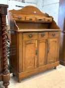 An Edwardian walnut sideboard, the raised arched back with open shelf and four trinket drawers