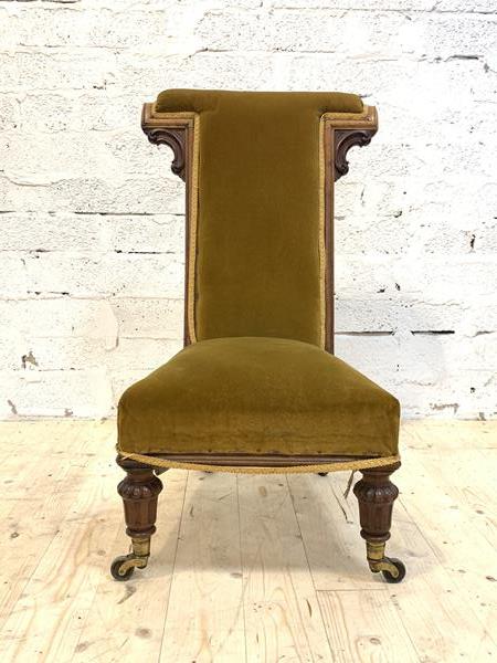 A Victorian walnut framed prie dieu, upholstered in yellow velvet, raised on turned and fluted