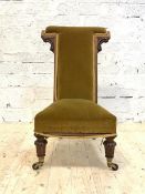 A Victorian walnut framed prie dieu, upholstered in yellow velvet, raised on turned and fluted