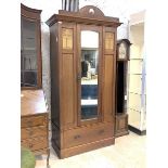 An early 20th century Art Nouveau period mahogany wardrobe, the mirrored door enclosing interior