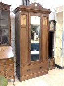 An early 20th century Art Nouveau period mahogany wardrobe, the mirrored door enclosing interior