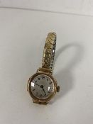 A 1930's ladies wrist watch interior case marked Chester 9ct gold on a rolled gold strap, dial