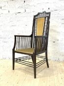 An early 20th century Arts and Crafts period mahogany armchair, having a spindle back and arm