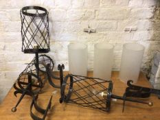 A set of three lantern style wall lights, the opaque cylinder glass shades within a cage style frame