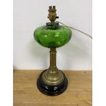 An Edwardian oil lamp with green glass reservoir on brass column style base later converted for